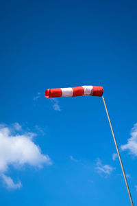 Low angle view of red umbrella against blue sky