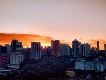 Buildings in city against sky at sunset