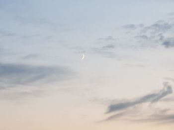 Low angle view of moon in sky at sunset