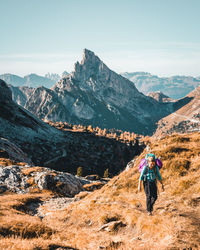 Woman hiking on mountain against sky