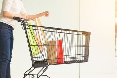 Low section of man holding umbrella standing at store