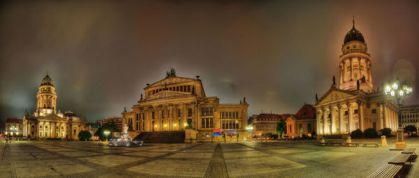 Illuminated buildings in city against sky at night