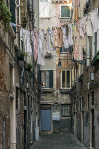 Clothes drying over alley amidst buildings in city