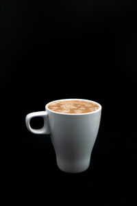 Close-up of coffee cup against black background