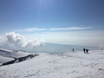 People on snow covered mountain against sky