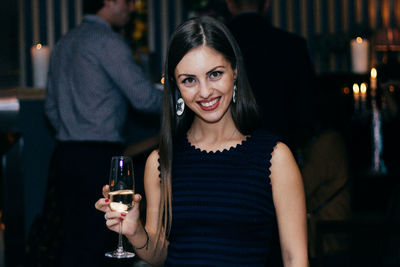 Portrait of smiling young woman having wine in party