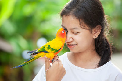 Close-up of girl holding bird