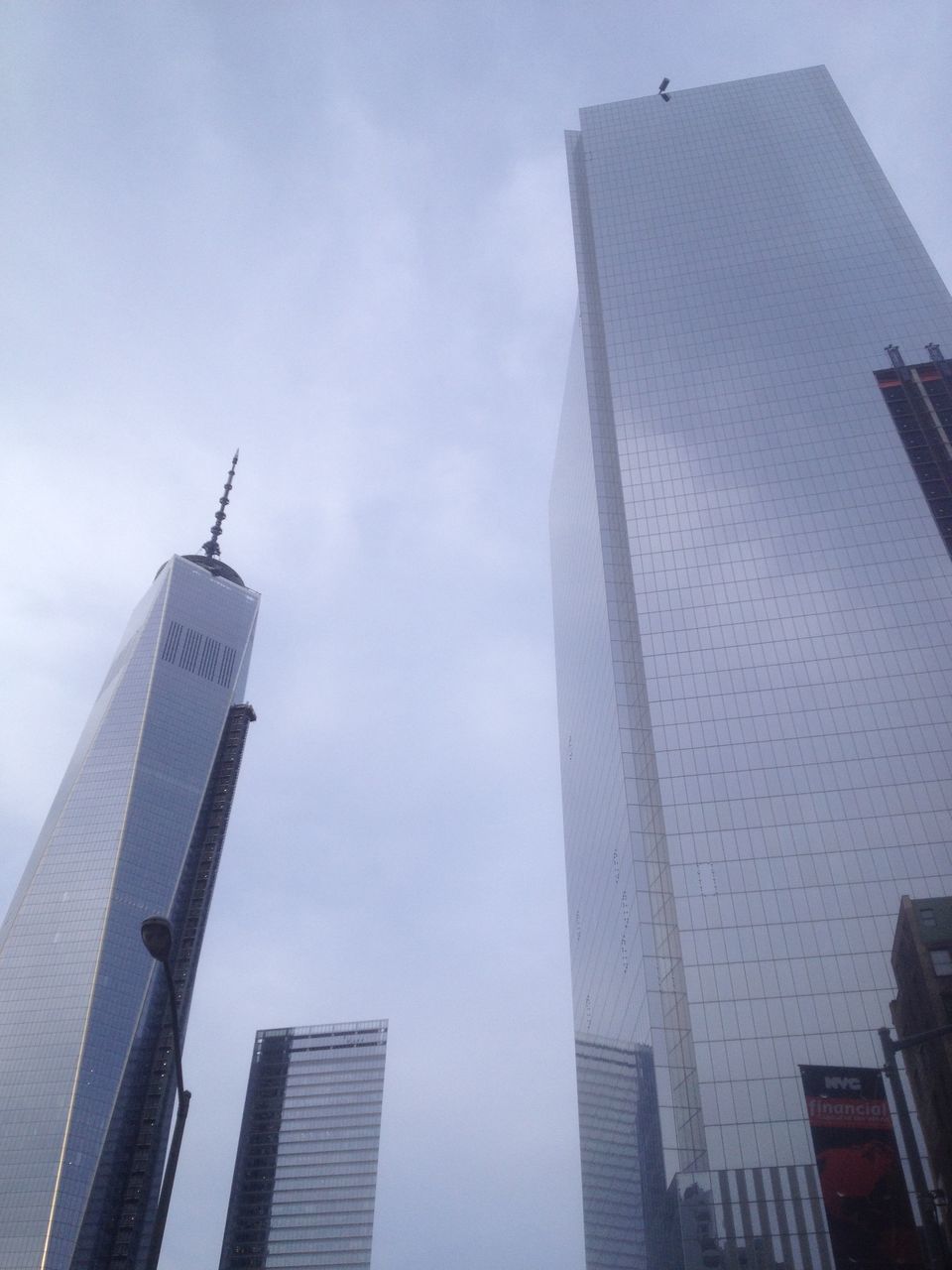 building exterior, architecture, built structure, low angle view, tall - high, skyscraper, city, tower, modern, building, office building, sky, airplane, day, outdoors, tall, no people, travel, clear sky, directly below