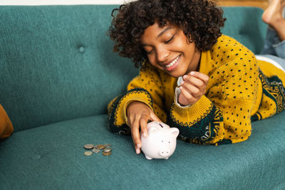 Portrait of woman with piggy bank on table