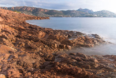 Scenic view of sea and mountains against sky