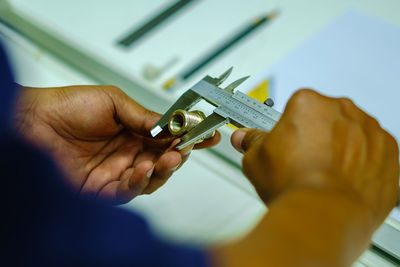 Cropped hands of man holding work tool