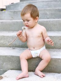 Cute baby boy sitting outdoors