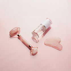 Beauty product with gua sha massage scraper and quartz roller. cosmetic bottle with gel. 