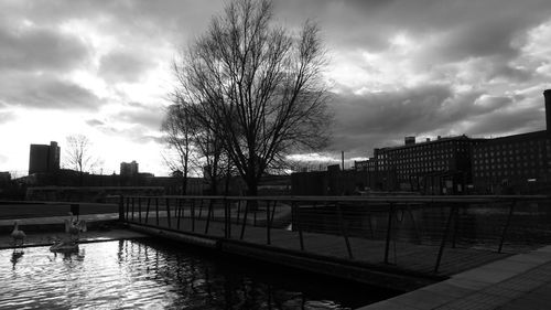 Bridge over river against cloudy sky