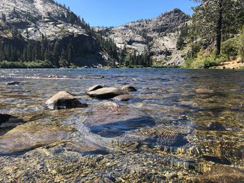 Scenic view of river by mountain against sky