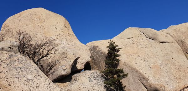 Low angle view of rock formation against clear blue sky