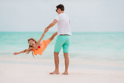 Full length of men on beach against sky