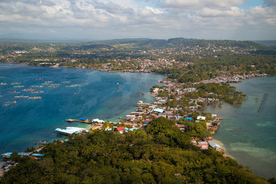 High angle view of townscape by sea against sky