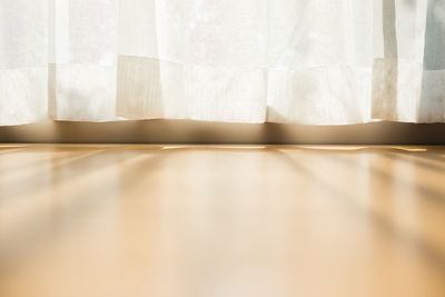 Close-up of white curtain on table at home