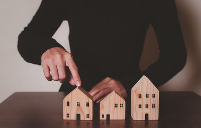 Midsection of man holding model house