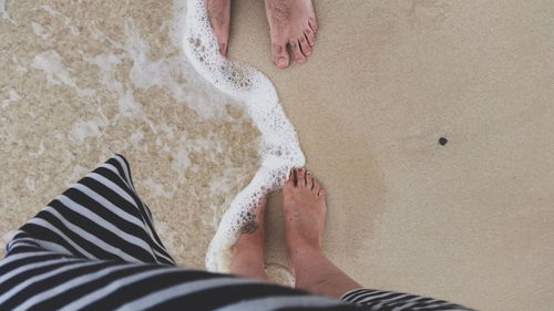 Low section of woman standing on beach