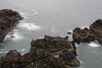 Rock formations on shore against sky