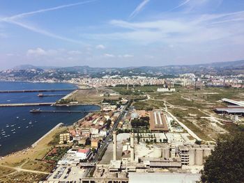 High angle view of cityscape and sea against sky