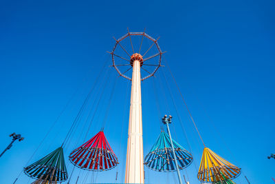 Low angle view of ferris wheel against clear blue sky