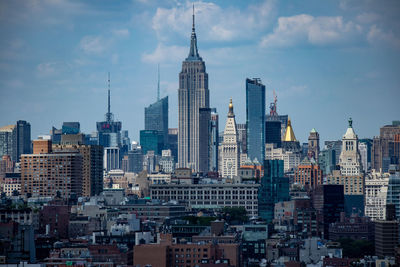 Buildings in city against cloudy sky