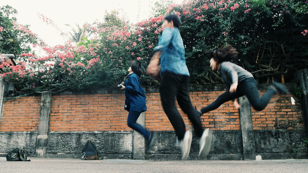 lifestyles, tree, leisure activity, full length, person, park - man made space, men, casual clothing, building exterior, built structure, fountain, sitting, architecture, outdoors, day, motion, togetherness