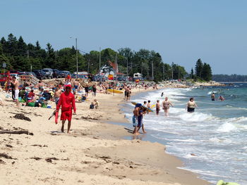 People at beach against clear sky