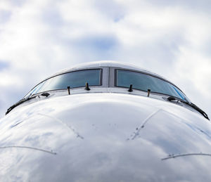 Cockpit of jet airplane against cloudy skies