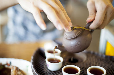 Close-up of human hands with teapot