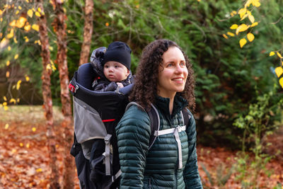 Portrait of smiling young woman standing in forest