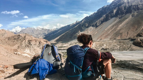 Rear view of friends looking at mountains against sky