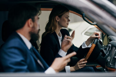 Side view of couple sitting in car