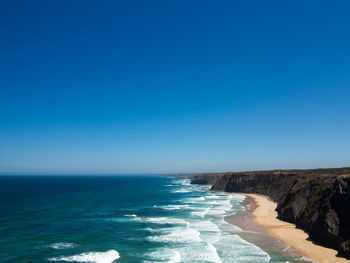 Scenic view of sea against clear blue sky