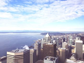 High angle view of buildings by sea against sky