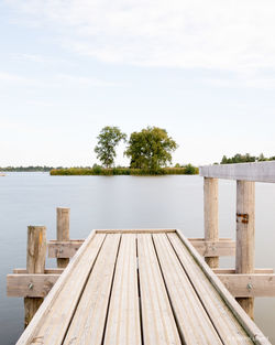 Wooden pier over lake against sky