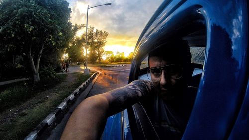 Portrait of man by car against sky