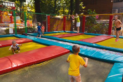 Rear view of people playing on playground