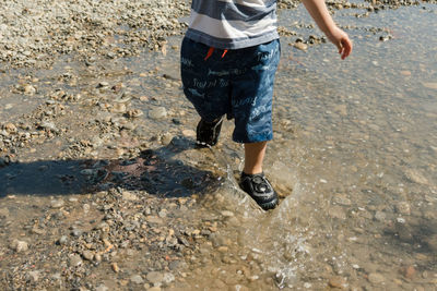 Low section of man standing on puddle