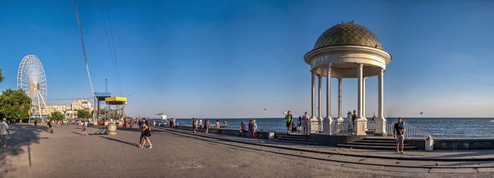 People at beach against blue sky