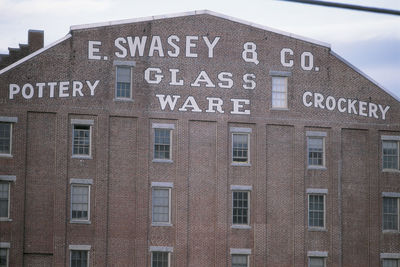 Low angle view of text on building against sky