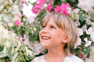 Portrait of face of a candid little happy smiling five year old blonde kid boy with green eyes