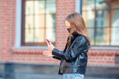 Girl wearing mask while using phone