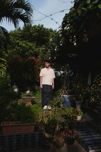 Rear view of woman standing against plants