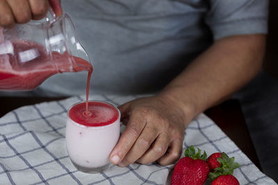 Midsection of man holding red drink