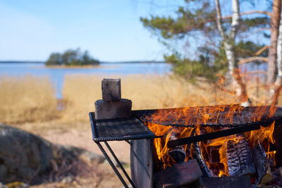 Fire in a rusty vintage grill outdoor on the beach of the sea.