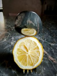 Close-up of lime by fork and spoon on marble